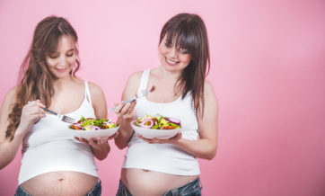 maternity concept, two pregnant woman eating fresh salad
